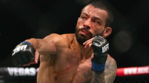 Dan Ige throws a punch in a featherweight mixed martial arts bout at a UFC event. (Altaf Qadri/AP)