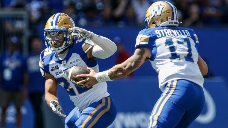 Winnipeg Blue Bombers quarterback Chris Streveler (17) hands off to DaMarcus Fields (22) during first half preseason CFL football action against the Saskatchewan Roughriders in Winnipeg, Saturday, May 24, 2025. (John Woods/CP)