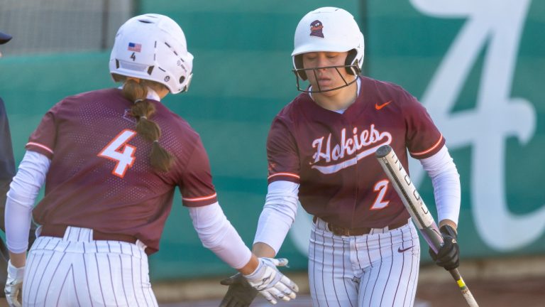Virginia Tech infield Michelle Chatfield (4) greets Virginia Tech outfielder Cori McMillan (2) after McMillan survived a play at the plate during an NCAA softball game against Drake on Friday, Feb. 21, 2025, in Tuscaloosa, Ala. (Vasha Hunt/AP)