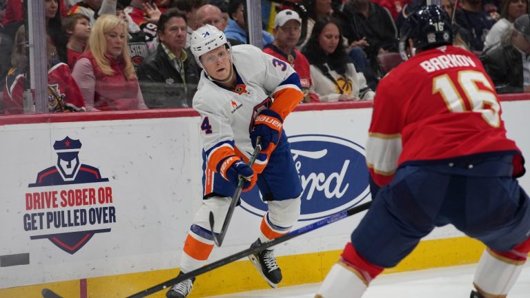 New York Islanders defenceman Adam Boqvist (34) passes the puck past Florida Panthers centre Aleksander Barkov (16) during the second period of an NHL hockey game, Sunday, Feb. 2, 2025, in Sunrise, Fla. (Lynne Sladky/AP Photo)