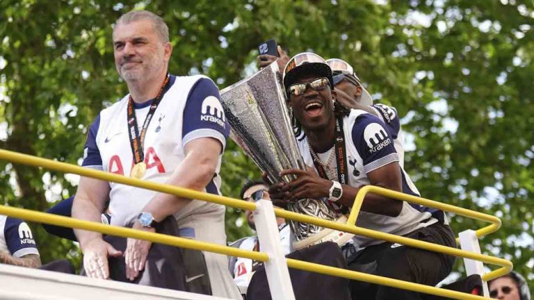 Tottenham Hotspur's Yves Bissouma and manager manager Ange Postecoglou with the trophy on the open-top team bus during the Europa League winners parade in North London, Friday, May 23, 2025. (John Walton/PA via AP)