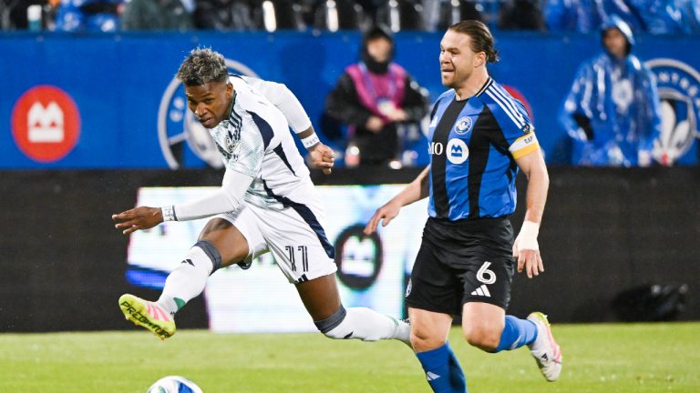 New England Revolution's Luis Diaz Espinoza (11) takes a shot on goal as CF Montreal's Samuel Piette (6) moves in during second half MLS soccer action in Montreal, Saturday, May 31, 2025. (Graham Hughes/CP)