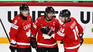 Canada's Sidney Crosby, centre, celebrates after scoring with teammates Nate MacKinnon, left, and Bo Horvat during the IIHF Ice Hockey World Championship group A match between Canada and France at Avicii Arena in Stockholm, Sweden, Tuesday, May 13, 2025. (Anders Wiklund/TT via AP)