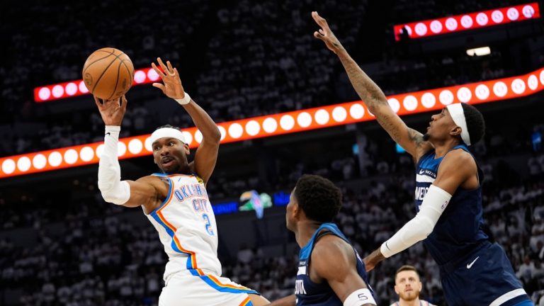 Oklahoma City Thunder guard Shai Gilgeous-Alexander (2) passes against Minnesota Timberwolves guard Anthony Edwards, center, and forward Jaden McDaniels, right, during the first half of Game 3 of the Western Conference finals of the NBA basketball playoffs, Saturday, May 24, 2025, in Minneapolis. (Abbie Parr/AP)
