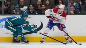 Montreal Canadiens defenseman Lane Hutson, right, passes the puck against San Jose Sharks center Macklin Celebrini during the first period of an NHL hockey game. (Jeff Chiu/AP)
