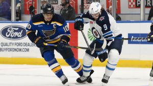 St. Louis Blues center Brayden Schenn, left, battles Winnipeg Jets left wing Alex Iafallo, right, during the first period in Game 6 of an NHL hockey first-round playoff series Friday, May 2, 2025, in St. Louis. (Jeff Le/AP Photo)