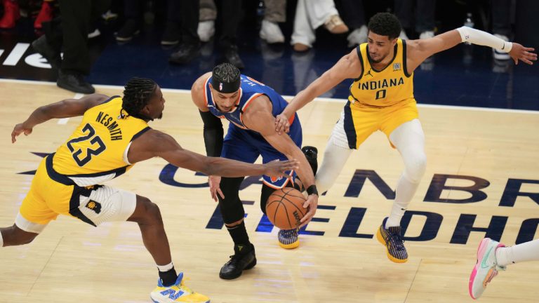 New York Knicks guard Josh Hart, middle, is defended by Indiana Pacers forward Aaron Nesmith (23) and guard Tyrese Haliburton (0) during the first half of Game 3 of the Eastern Conference finals of the NBA basketball playoffs Sunday, May 25, 2025, in Indianapolis. (Jeff Roberson/AP)