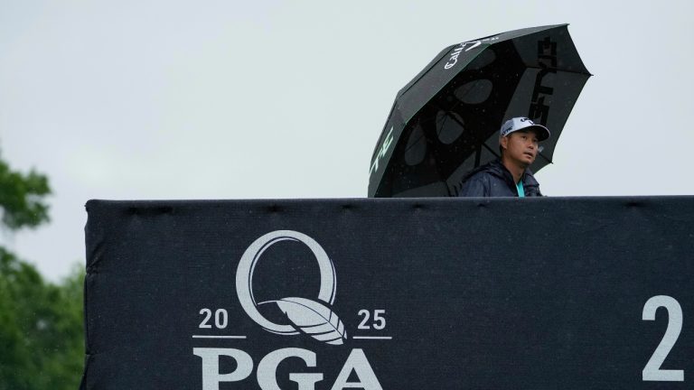 A person walks in the rain over a pedestrian bridge during a practice round for the PGA Championship golf tournament at the Quail Hollow Club, Monday, May 12, 2025, in Charlotte, N.C. (AP Photo/Matt York)
