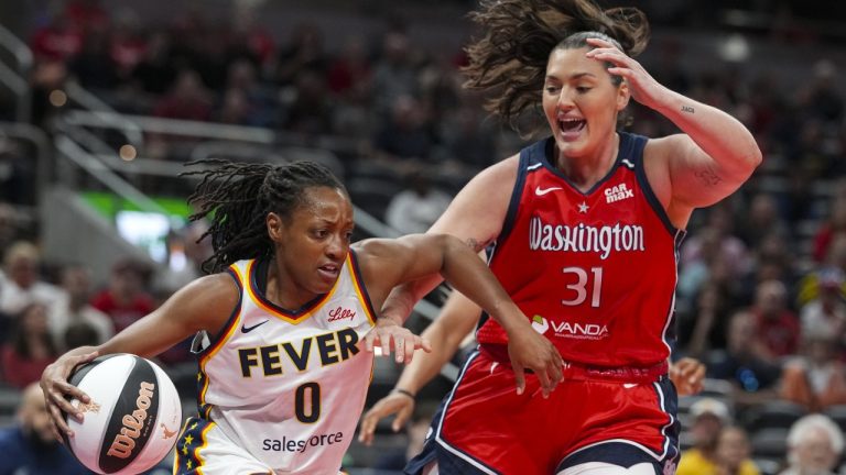 Indiana Fever guard Kelsey Mitchell (0) drives on Washington Mystics center Stefanie Dolson (31) in the first half of a WNBA basketball game in Indianapolis, Tuesday, June 3, 2025. (AP Photo/Michael Conroy)