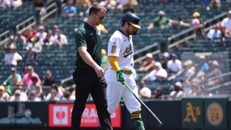 Athletics' Shea Langeliers leaves the game and walks back to the dugout with a trainer after taking a swing and grabbing his side during the sixth inning of a game against the Minnesota Twins Thursday, June 5, 2025. (Scott Marshall/AP)