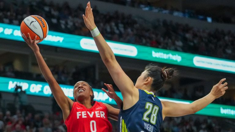 Indiana Fever guard Kelsey Mitchell (0) goes up for a basket against Dallas Wings center Li Yueru (28) during the first half of a WNBA basketball game Friday, June 27, 2025, in Dallas. (AP Photo/Julio Cortez)