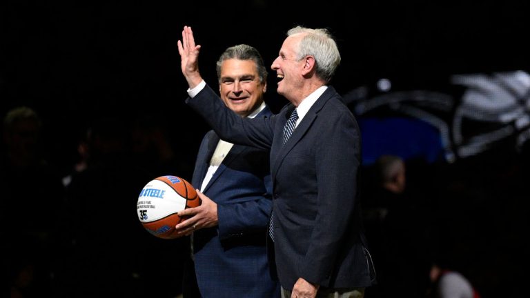 Orlando Magic broadcaster David Steele, right, is honoured by Magic CEO Alex Martins on the court during the first half of an NBA basketball game against the New Orleans Pelicans, Thursday, March 21, 2024, in Orlando, Fla. (Phelan M. Ebenhack/AP)