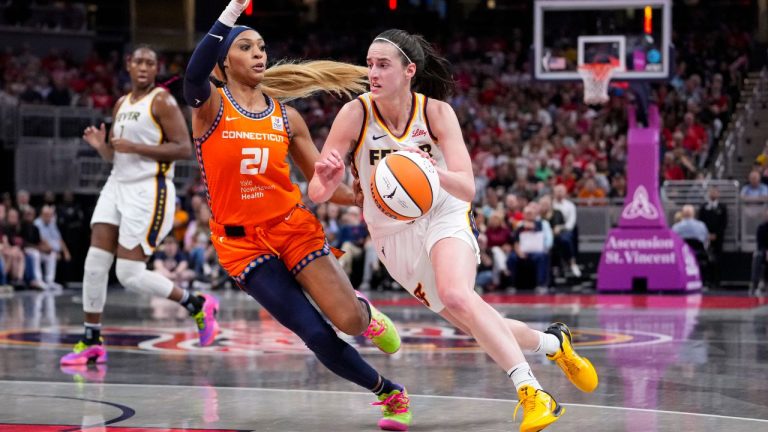 Indiana Fever guard Caitlin Clark (22) splits between Connecticut Sun forward Brionna Jones (42) and Connecticut Sun guard Veronica Burton (22) during a first-round WNBA basketball playoff game, Wednesday, Sept. 25, 2024, in Uncasville, Conn. (Jessica Hill/AP)