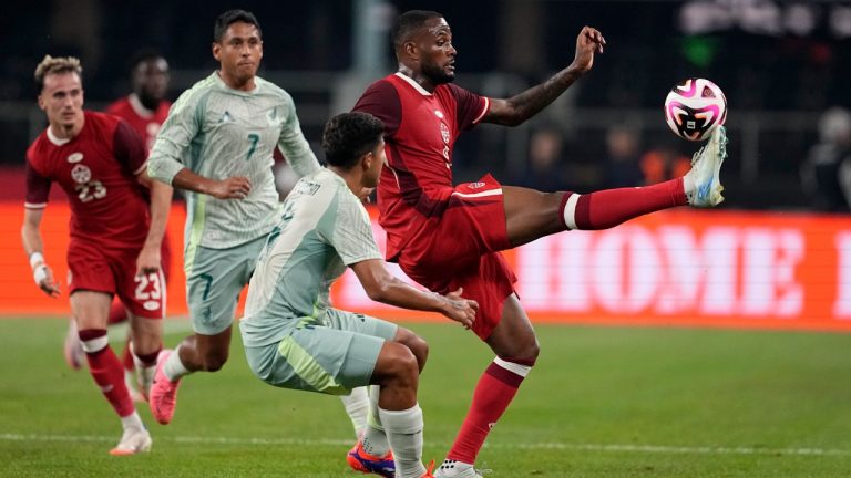 Canada forward Cyle Larin, right, reaches out to take control of a pass as Mexico defenceman Victor Guzman, centre front, defends in the first half of an international friendly soccer match, Tuesday, Sept. 10, 2024, in Arlington, Texas. (Tony Gutierrez/AP)