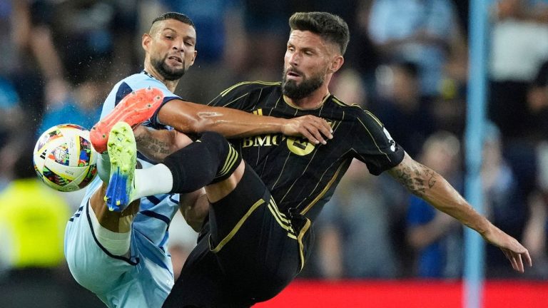 Sporting Kansas City defender Joaquin Fernandez, left, and Los Angeles FC attacker Olivier Giroud (9) battle for the ball during the first half of an MLS soccer match Saturday, Oct. 5, 2024, in Kansas City, Kan. (Charlie Riedel/AP)