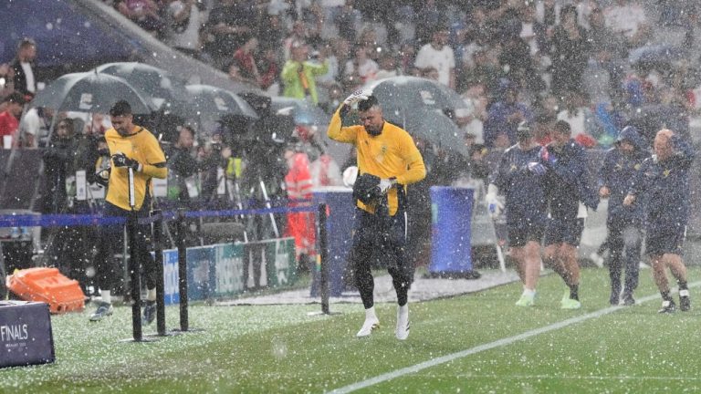 Portugal goalkeeper Diogo Costa, center, runs from the pitch during a hailstorm before the Nations League semifinal soccer match between Portugal and Germany at the Munich Football Arena, in Munich, Germany, Wednesday, June 4, 2025. (Martin Meissner/AP)