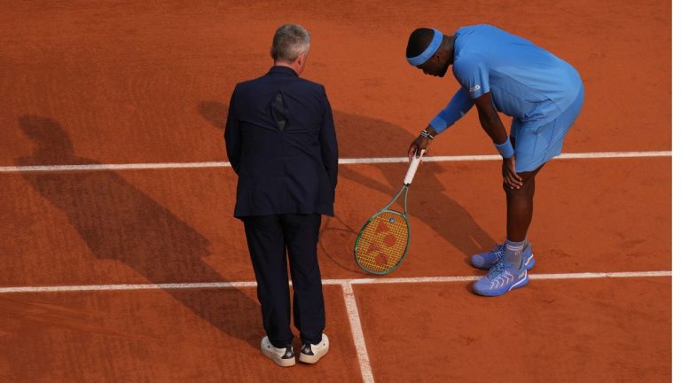 United States' Frances Tiafoe and the chair umpire check the mark on the clay as he plays against Italy's Lorenzo Musetti during their quarterfinal match of the French Tennis Open at the Roland-Garros stadium in Paris, Tuesday, June 3, 2025. (Thibault Camus/AP)
