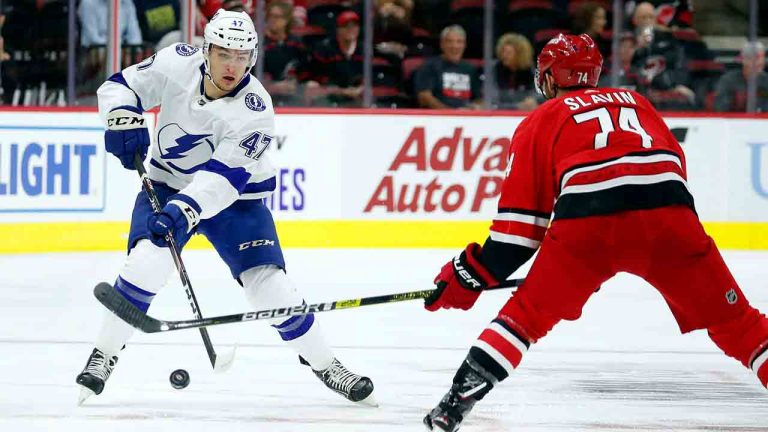 Tampa Bay Lightning's Jimmy Huntington (47) clears the puck around Carolina Hurricanes' Jaccob Slavin (74) during the first period of an NHL preseason hockey game, in Raleigh, N.C, Wednesday, Sept. 18, 2019, (Karl B DeBlaker/AP)