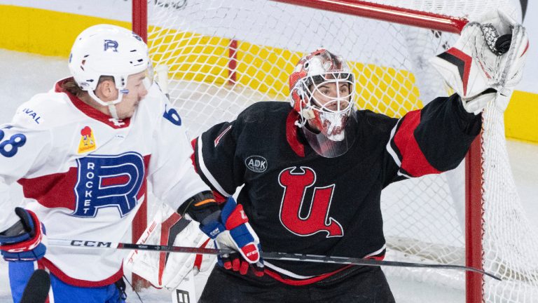 Utica Comets goaltender Isaac Poulter (1) makes a glove save over Laval Rocket's Riley McKay (68) during second period AHL hockey action in Laval on Wednesday, Jan. 31, 2024. (Christinne Muschi/CP)