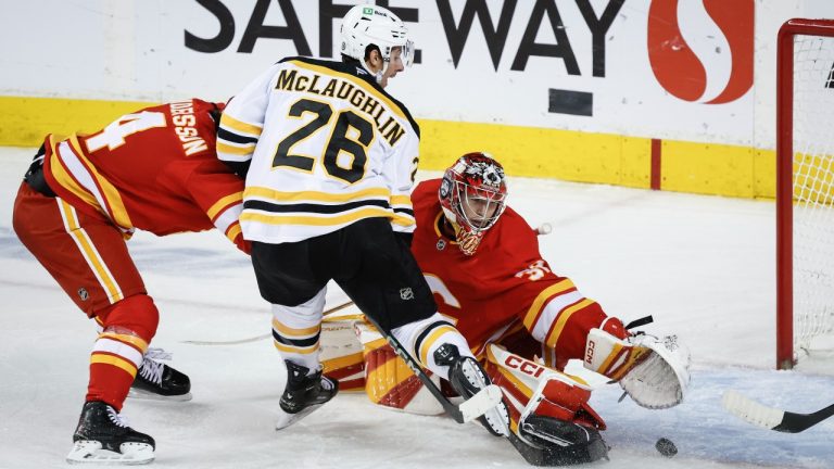 Boston Bruins' Marc McLaughlin, centre, scores on Calgary Flames goalie Dustin Wolf during third period NHL hockey action in Calgary on Tuesday, Dec. 17, 2024.THE CANADIAN PRESS/Jeff McIntosh