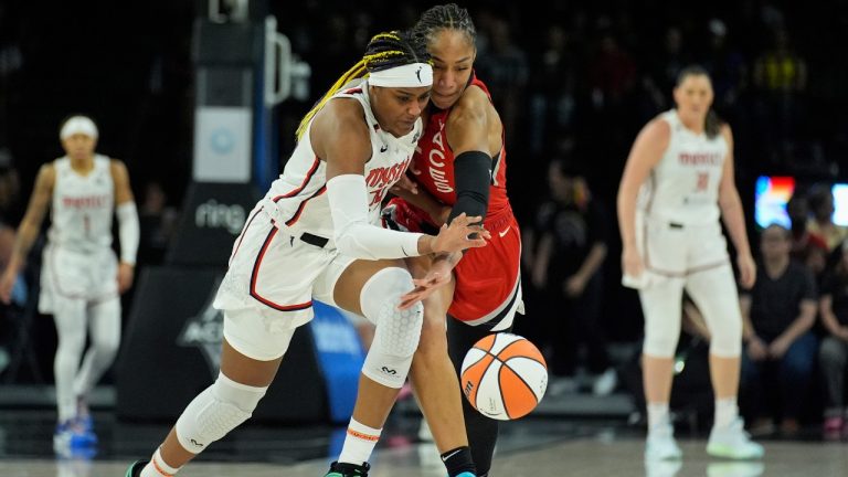 Washington Mystics forward Aaliyah Edwards, left, and Las Vegas Aces center A'ja Wilson (22) vie for the ball during the first half of a WNBA basketball game Thursday, June 26, 2025, in Las Vegas. (John Locher/AP)