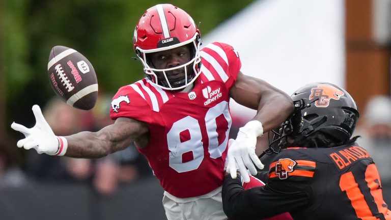 Calgary Stampeders' Damien Alford, left, reaches for the ball as B.C. Lions' Travian Blaylock defends during the second half of a preseason CFL football game, in Langford, B.C., on Monday, May 19, 2025. (Darryl Dyck/CP)