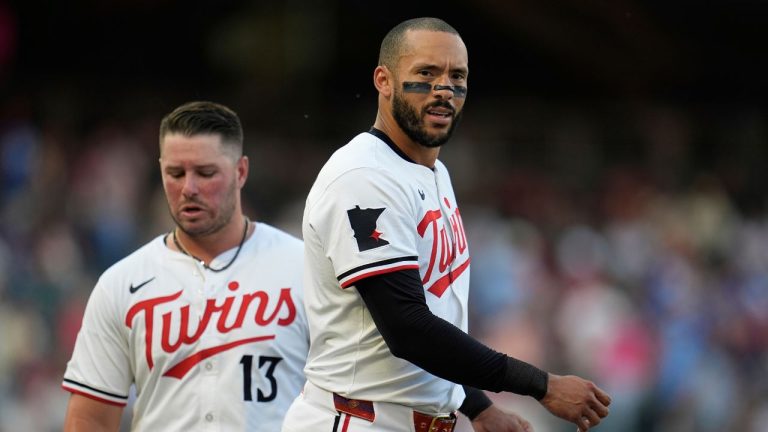Minnesota Twins' Carlos Correa, right, walks across the field near Ty France (13) after hitting a lineout to third base to end the bottom of the third inning of a baseball game against the Washington Nationals, Saturday, July 26, 2025, in Minneapolis. (Abbie Parr/AP)