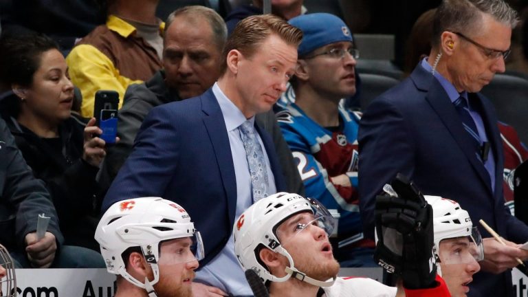 Glen Gulutzan, back, watches as the Flames face the Colorado Avalanche during the first period of an NHL hockey game Wednesday, Feb. 28, 2018, in Denver. (David Zalubowski/AP)