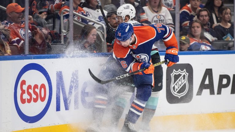 Seattle Kraken's Brandon Biro (11) is checked by Edmonton Oilers' Philip Kemp (76) during third period NHL pre-season action in Edmonton on Saturday September 28, 2024. (Jason Franson/THE CANADIAN PRESS)