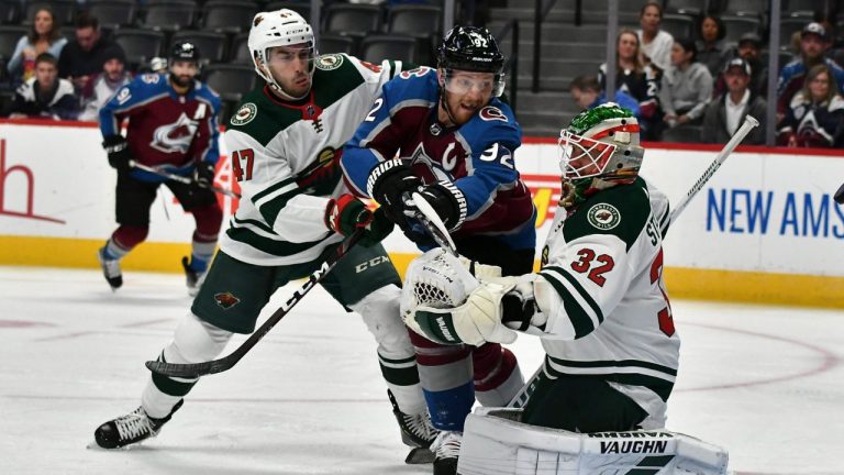 Colorado Avalanche left wing Gabriel Landeskog (92) gets pressure from Minnesota Wild's Louie Belpedio (47) as he deflects the puck past Wild goaltender Alex Stalock (32) during the first period in an NHL preseason hockey game Sunday, Sept. 22, 2019 in Denver (John Leyba/AP)