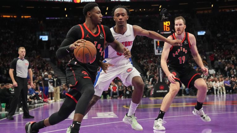 Toronto Raptors' RJ Barrett drives past Detroit Pistons' forward Ronald Holland II as Raptors Jakob Poeltl looks on during first half NBA Cup basketball action in Toronto on Friday, November 15, 2024. (Chris Young/CP)