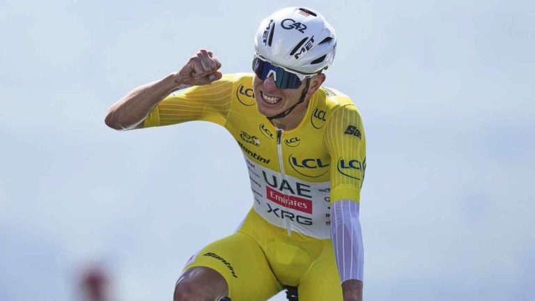 Slovenia's Tadej Pogacar, wearing the overall leader's yellow jersey, celebrates winning the thirteenth stage of the Tour de France cycling race. (Thibault Camus/AP)
