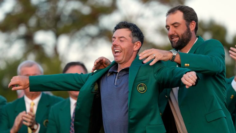 Scottie Scheffler puts the green Jacket on winner, Rory McIlroy, of Northern Ireland, at the Masters golf tournament, Sunday, April 13, 2025, in Augusta, Ga. (Ashley Landis/AP)