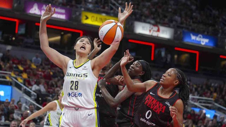 Dallas Wings center Li Yueru (28) looses the ball over Indiana Fever guard Kelsey Mitchell (0) in the first half of a WNBA basketball game in Indianapolis, Tuesday, Aug. 12, 2025. (Michael Conroy/AP)