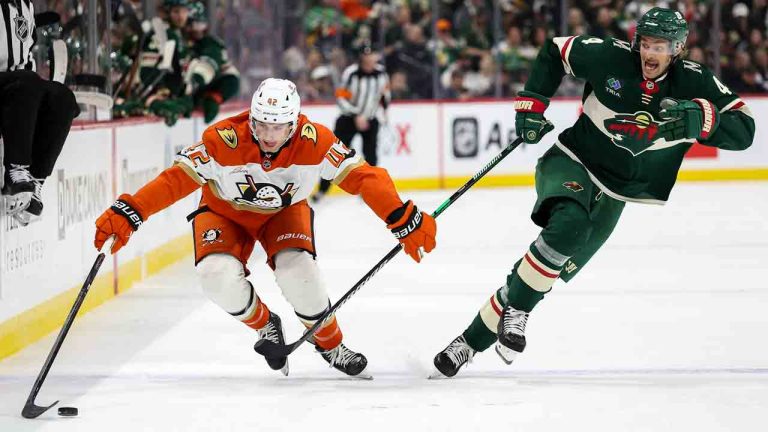 Anaheim Ducks center Tim Washe, left, skates with the puck alongside Minnesota Wild defenseman Jon Merrill during the second period of an NHL hockey game, Tuesday, April 15, 2025, in St. Paul, Minn. (Matt Krohn/AP)