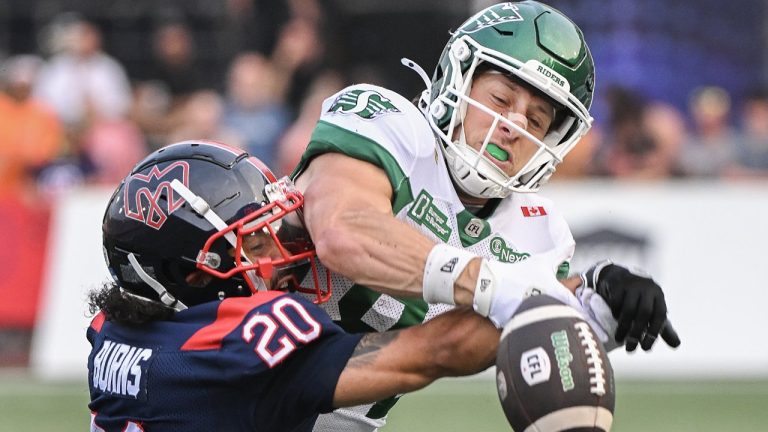 Montreal Alouettes' Lorenzo Burns (20) challenges Saskatchewan Roughriders' Joe Robustelli for the ball during first half CFL football action in Montreal, Saturday, Aug. 2, 2025. THE CANADIAN PRESS/Graham Hughes