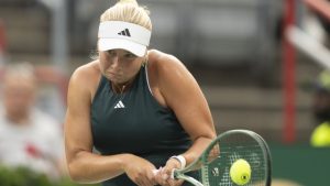 Clara Tauson of Denmark hits a return to Iga Swiatek of Poland during round of 16 tennis action at the National Bank Open in Montreal, Sunday, Aug. 3, 2025. THE CANADIAN PRESS/Christinne Muschi