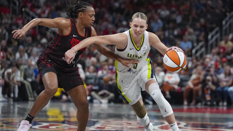 Dallas Wings guard Paige Bueckers (5) drives on Indiana Fever guard Kelsey Mitchell (0) in the first half of a WNBA basketball game in Indianapolis, Tuesday, Aug. 12, 2025. (AP Photo/Michael Conroy)
