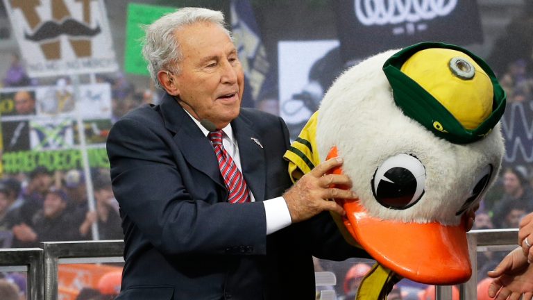 ESPN College GameDay host Lee Corso puts on the mascot head of the Oregon Ducks, Oct. 12, 2013, during their broadcast from Red Square on the University of Washington campus in Seattle. (Ted S. Warren/AP)