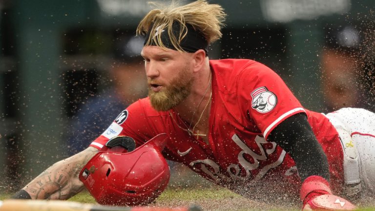 Cincinnati Reds' Jake Fraley dives safely into home plate to score on a double hit by Tyler Stephenson during the second inning of a baseball game against the Atlanta Braves, Thursday, July 31, 2025, in Cincinnati. (Carolyn Kaster/AP)