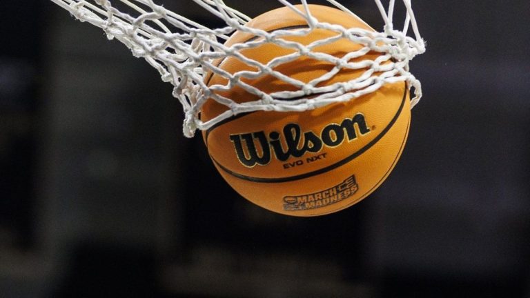 A basketball with a March Madness logo is seen going through a net prior to a second round of the NCAA college basketball tournament between Notre Dame and Michigan, March 23, 2025, in South Bend, Ind. (John Mersits/AP)