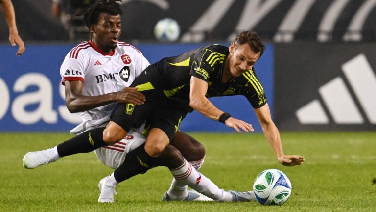 Toronto FC's Deandre Kerr (left) tackles Columbus Crew's Daniel Gazdag during first half MLS soccer action in Toronto on Saturday, Aug. 16, 2025. (Jon Blacker/CP)