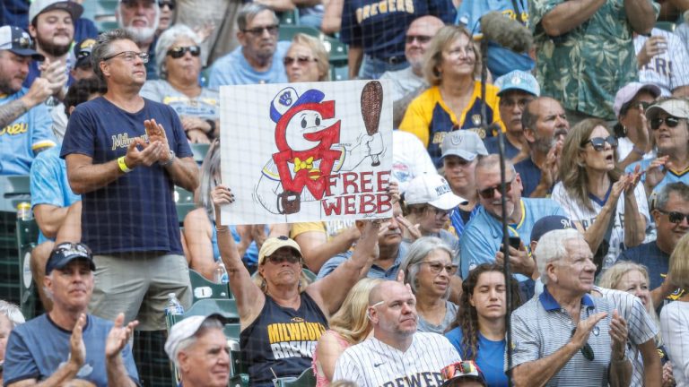 A fan holds up a sign during the fourth inning of a baseball between the Pittsburgh Pirates and Milwaukee Brewers game, Wednesday, Aug. 13, 2025, in Milwaukee. (AP Photo/Jeffrey Phelps)