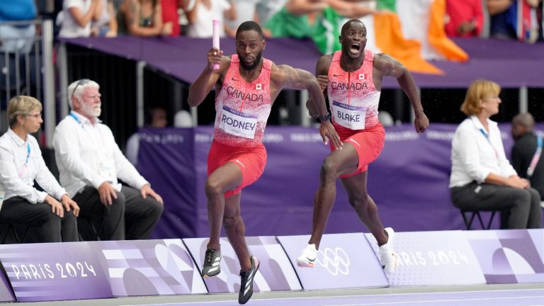 Canada's Jerome Blake cheers as teammate Brendon Rodney runs the baton in the men's 4 x 100m relay during the Paris Summer Olympics in Saint-Denis, France, Friday, Aug. 9, 2024. (Nathan Denette/CP)