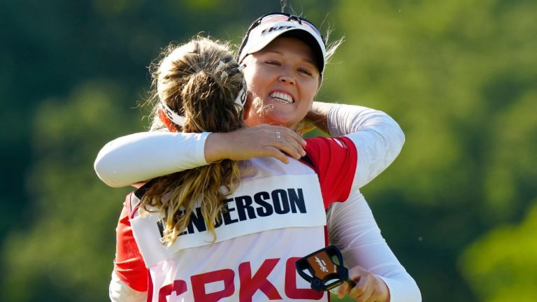 Brooke Henderson of Canada, right, hugs her caddie sister Brittany Henderson as she after winning the Canadian Women's Open on the 18th hole at Mississauga Golf and Country Club in Mississauga, Ontario on Sunday August 24, 2025. (Frank Gunn/CP)