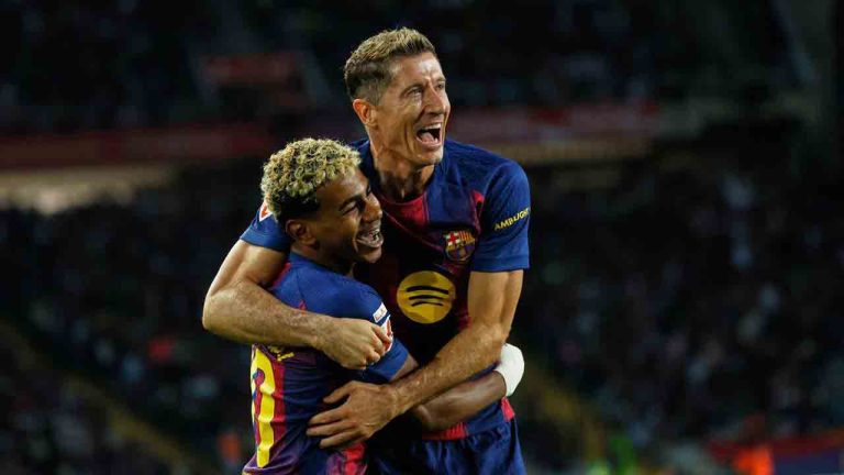 Barcelona's Robert Lewandowski, top, celebrates with Lamine Yamal scoring his side's 2nd goal during a Spanish La Liga soccer match between FC Barcelona and Real Sociedad at the Lluis Companys Olympic Stadium in Barcelona, Spain, Sunday, Sept. 28, 2025. (Joan Monfort/AP)