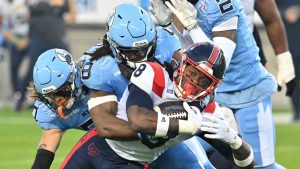 Former Toronto Argonauts linebacker Wynton McManis, centre left, tackles Montreal Alouettes running back Stevie Scott III (8) during first half CFL football action in Toronto Friday, Sept. 19, 2025. (Jon Blacker/CP)