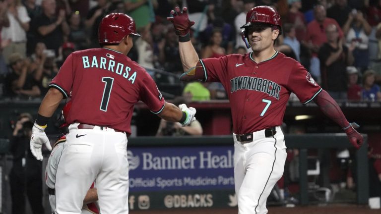 Arizona Diamondbacks' Corbin Carroll, right, celebrates with Jorge Barrosa (1) after hitting a three-run home run against the Philadelphia Phillies in the second inning of a baseball game, Sunday, Sept. 21, 2025, in Phoenix. (AP Photo/Rick Scuteri)