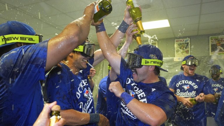 Toronto Blue Jays' Davis Schneider, centre right, celebrates with teammates in the clubhouse after their baseball game against the Kansas City Royals, Sunday, Sept. 21, 2025, in Kansas City, Mo. (AP Photo/Charlie Riedel)