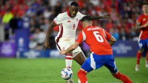 Canada striker Cyle Larin (9) and Chile defender Thomas Galdames (6) compete for the ball. (Phelan M. Ebenhack/AP)